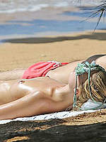 Margot Robbie sunbathing topless on a beach